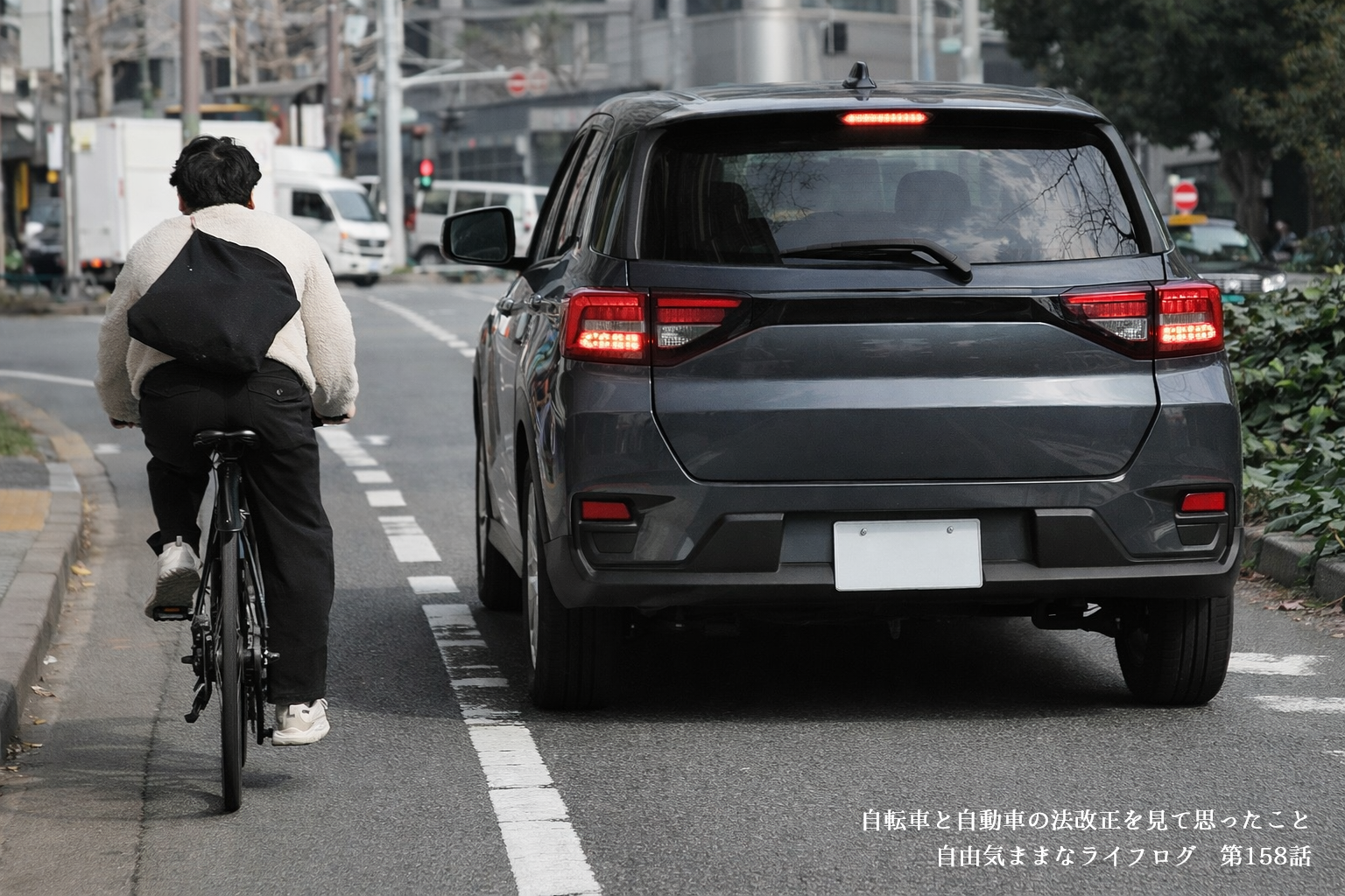 自転車と車が同じ道路を走り、適度な距離感の中で共存している様子