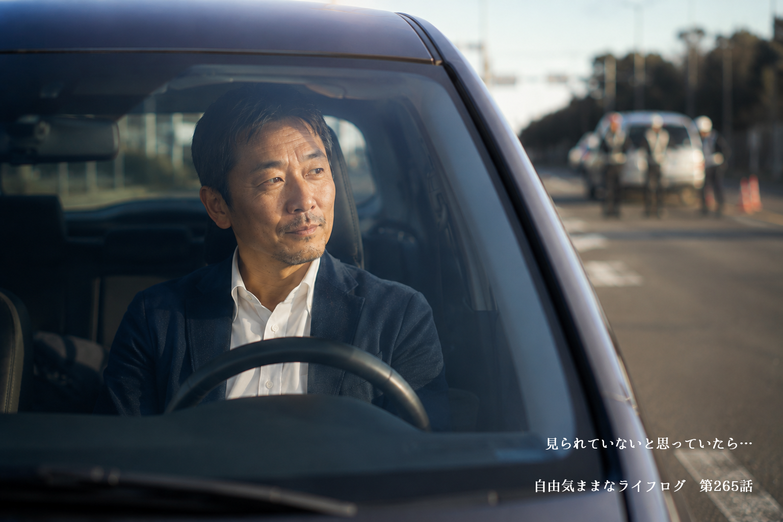 エンジンを切った車内でスマートフォンを確認しながら交通安全について考える男性